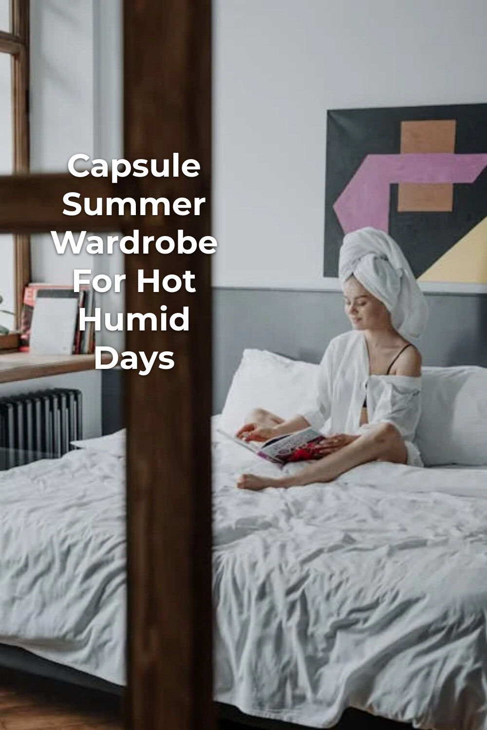 Capsule summer wardrobe inspiration: woman in white shirt reading a magazine on bed by window with towel-wrapped hair