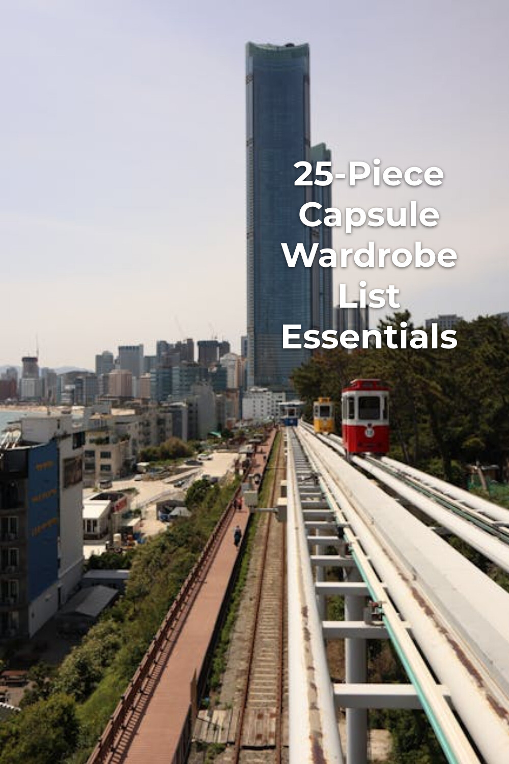 Capsule wardrobe list inspiration with a red train on elevated tracks heading toward a modern city skyline
