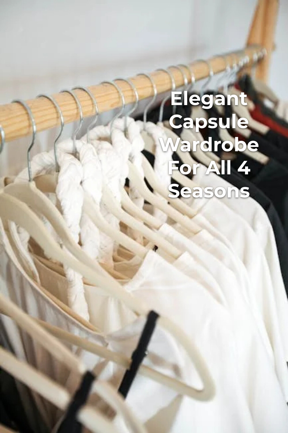 Elegant Capsule Wardrobe in Black and White Elegant capsule wardrobe with white and black clothes on hangers hanging from a wooden rod