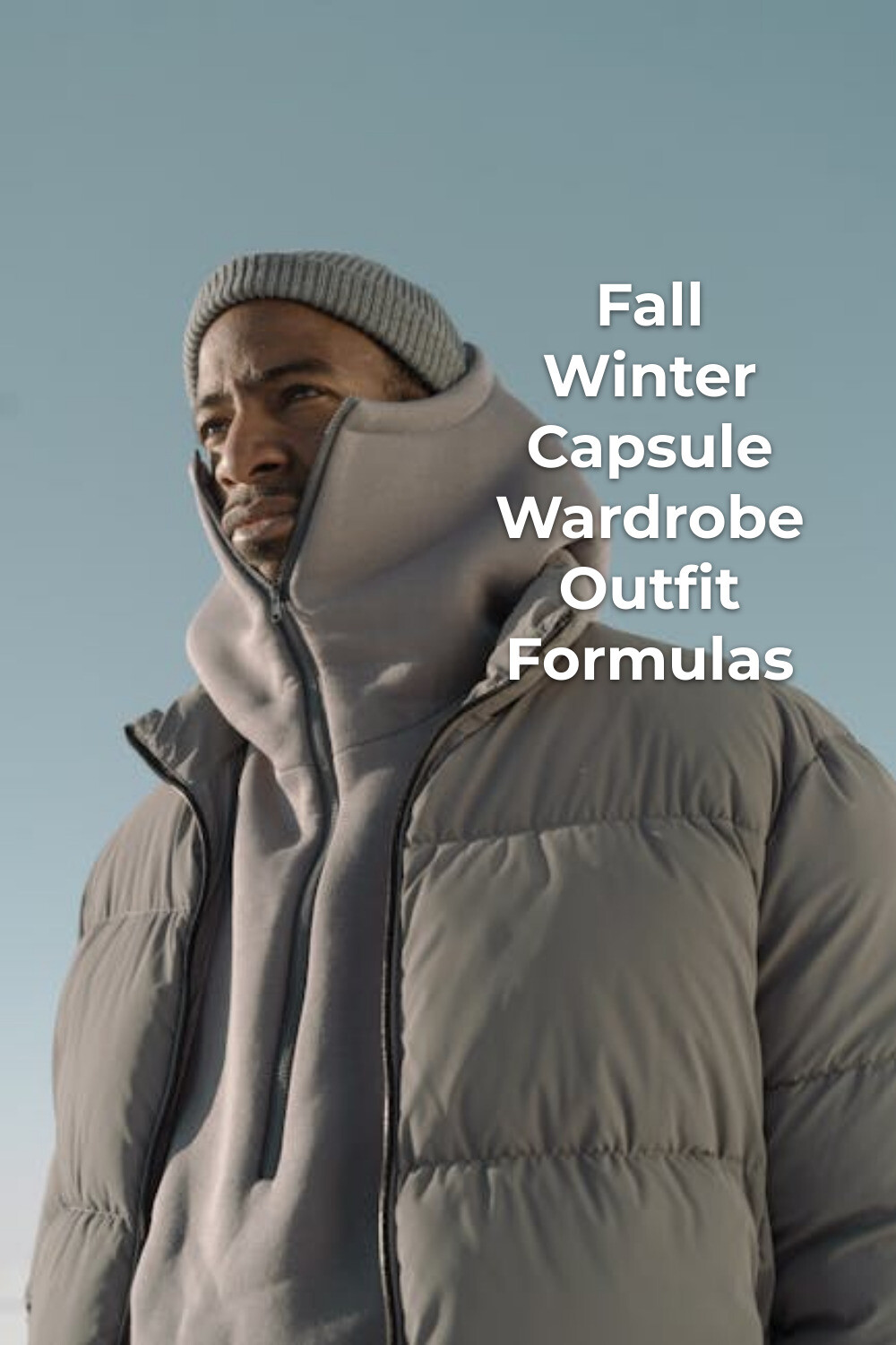 Fall winter capsule wardrobe look with beanie, hoodie, and padded jacket under a clear sky