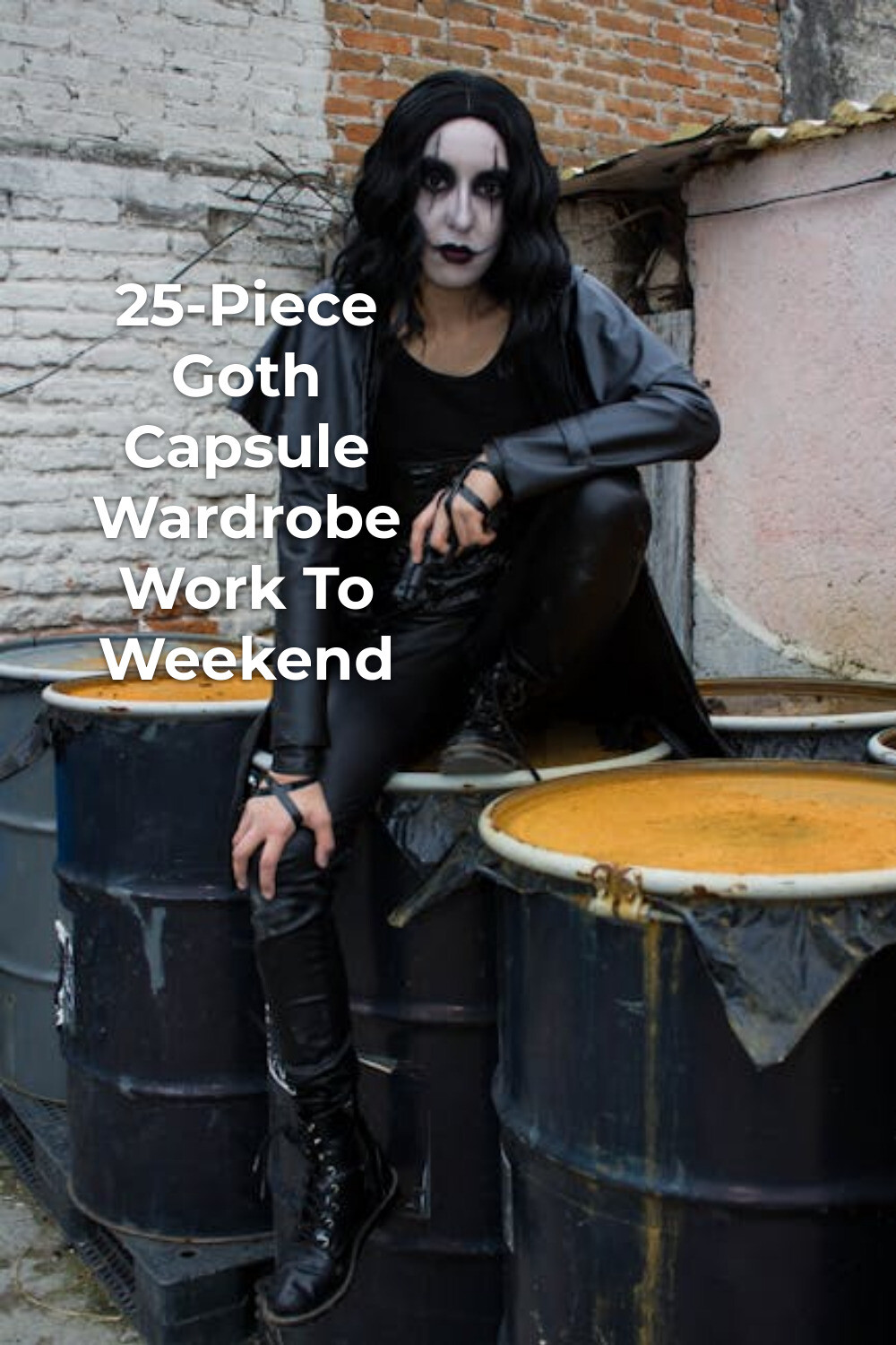 Goth Capsule Wardrobe Minimalist Black Outfit Goth capsule wardrobe look with black outfit and boots, crouching on barrels in a worn brick courtyard