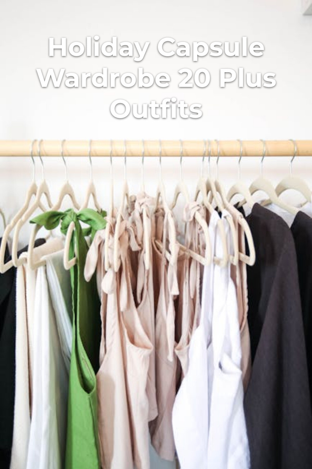 Holiday Capsule Wardrobe in Neutral Tones Holiday capsule wardrobe in green, beige, white and black on wooden hangers against a white wall