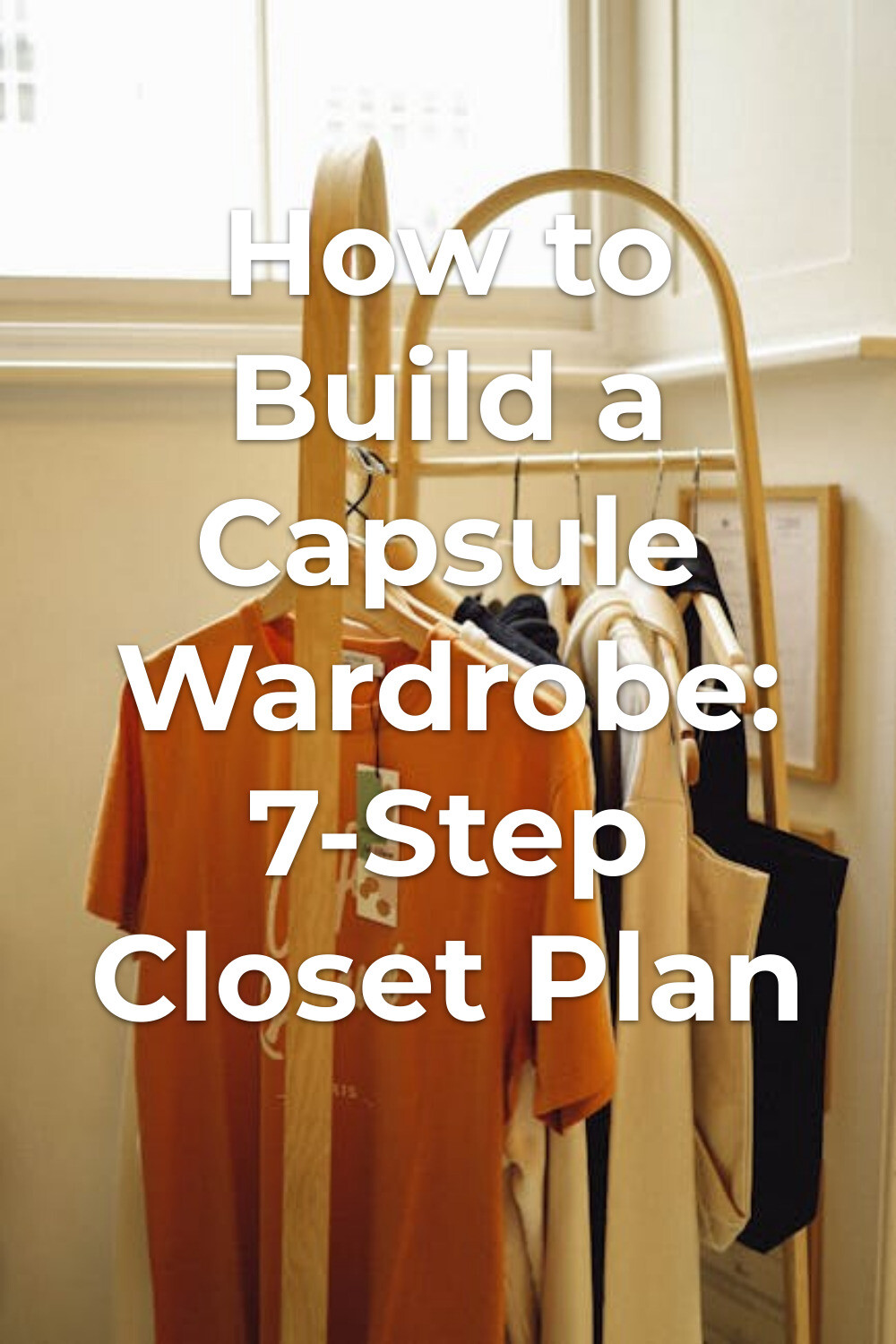 Capsule wardrobe clothes on a minimalist rack Capsule wardrobe essentials on hangers on a wooden rack by a window in a minimalist room