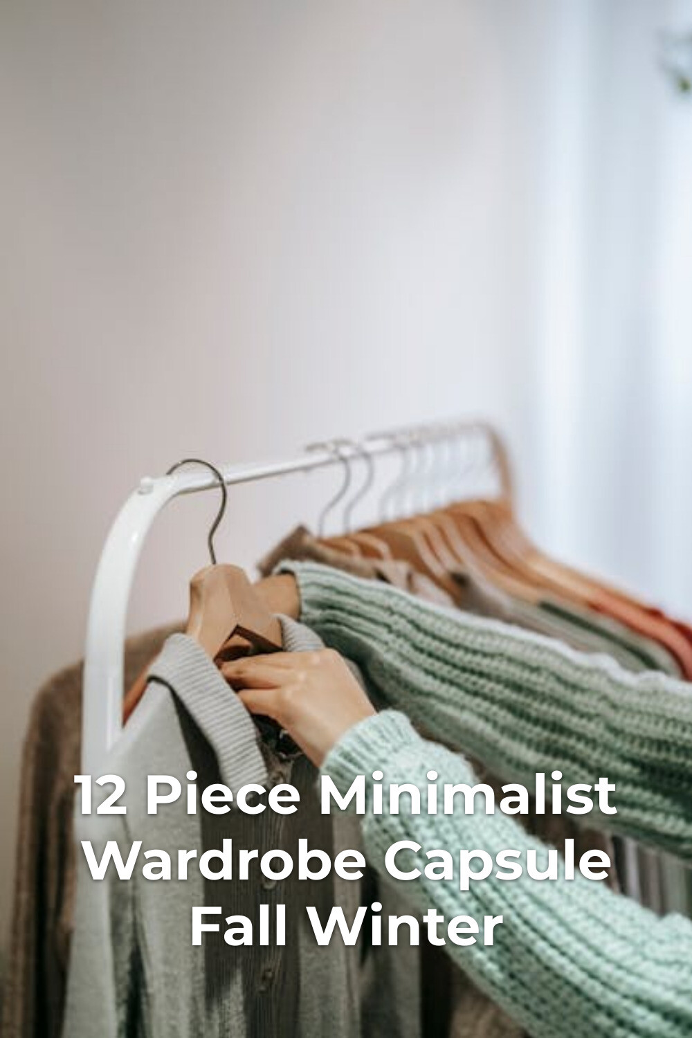 Minimalist Wardrobe Capsule Outfit Selection Minimalist wardrobe capsule styling with knit sweater holding gray shirt on hanger by a clothing rack