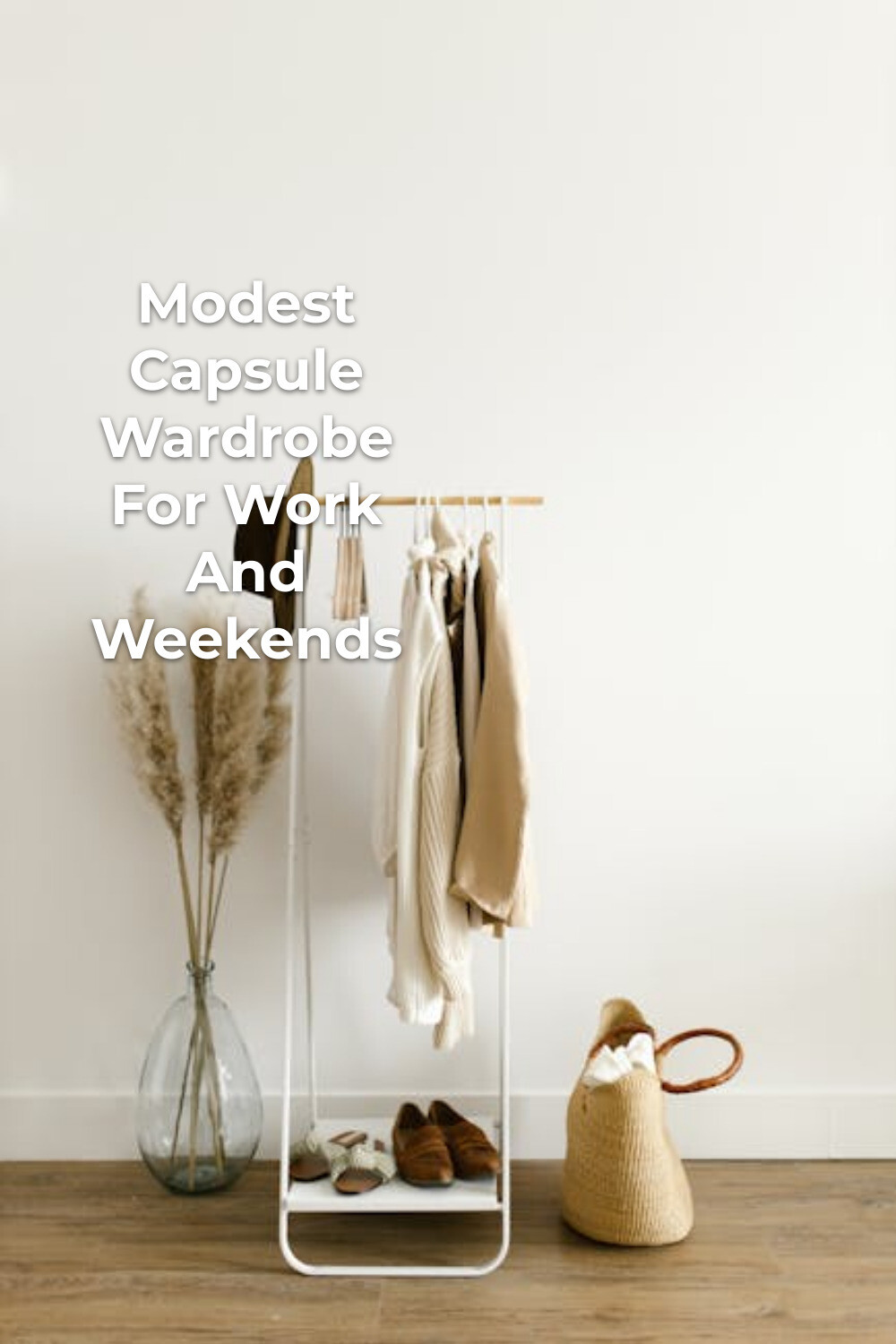 Minimalist Modest Capsule Wardrobe Display Modest capsule wardrobe on a white clothing rack with light clothes, hat, shoes, dried plants and woven basket